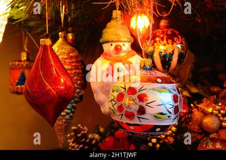 Weihnachtsbaumschmuck aus Glas hängt in einem Zierbaum. Stockfoto