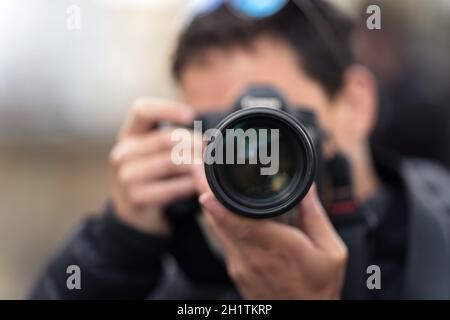 Fotograf Reporter, der ein Foto macht, Nahaufnahme des Objektivs. Stockfoto