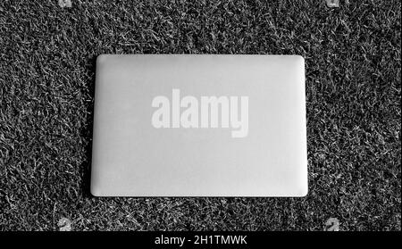 Laptop auf grünem Gras. Agiles Business. Fernlernkonzept. Immer online verfügbar Stockfoto