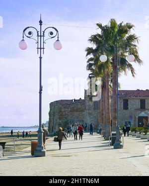 LARNACA, ZYPERN - 17. FEBRUAR 2019: Menschen zu Fuß am Resort Böschung von Larnaca, Laranaca Burg und Festung im Hintergrund Stockfoto