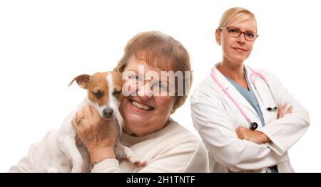 Glückliche ältere Frau mit ihrem Hund und Tierarzt isoliert auf einem weißen Hintergrund. Stockfoto