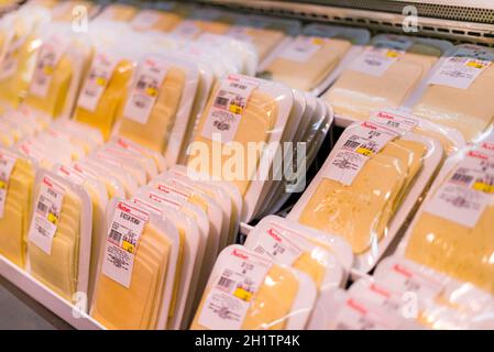 POZNAN, POL - APR 28, 2021: Käse wird in der Milchabteilung eines Supermarkts zum Verkauf angeboten Stockfoto