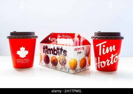 Calgary, Alberta, Kanada. 7.Mai 2021. Ein paar Tim Hortons Kaffeetassen mit einer Timbits-Box. Stockfoto