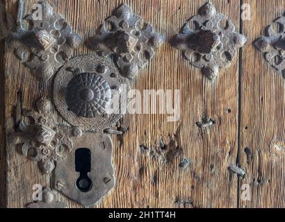 Altes Eisenschloss, an einer Holztür, mit ornamentalen Details in Form einer Blume Stockfoto