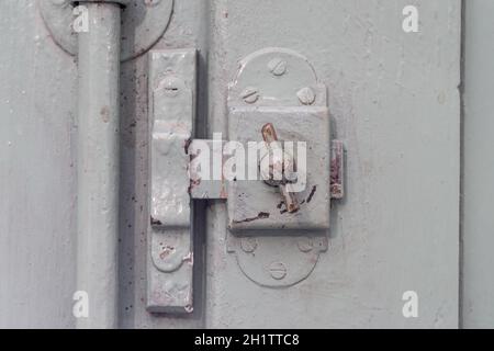 Detail altes Fenster Schloss auf vintage Holztür, lackiert Abdeckung Holz, Metall und Schrauben Stockfoto