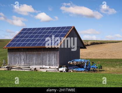 Grüner Energie mit Solarkollektoren auf dem Dach eines landwirtschaftlichen Gebäudes Stockfoto