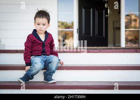 Süße Melancholie Mischlinge Junge sitzt auf der Veranda Schritte. Stockfoto