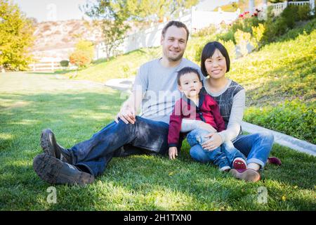 Happy Mixed Race Familie Spaß draußen auf dem Rasen. Stockfoto