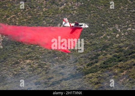 Winchester, CA USA - 14. Juni 2020: CAL Fire Aircraft fällt feuerhemmend auf einem trockenen Waldbrand auf einem Hügel in der Nähe von Winchester, Kalifornien. Stockfoto