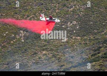 Winchester, CA USA - 14. Juni 2020: CAL Fire Aircraft fällt feuerhemmend auf einem trockenen Waldbrand auf einem Hügel in der Nähe von Winchester, Kalifornien. Stockfoto