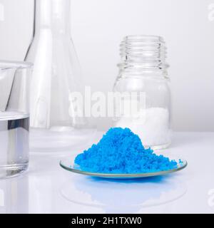 Nahaufnahme anorganischer Chemikalien auf weißem Labortisch. Kupfer(II)-Sulfat, mikrokristallines Wachs und Alkohol. Chemischer Inhaltsstoff für Kosmetik und To Stockfoto