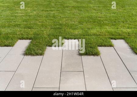 Rasengras und Gehweg auf dem Wandergebiet im Garten oder Park. Landschaftsgestaltung des Rasens und Verbesserung des Territoriums in der Nähe des Hauses. Hochwertige Fotos Stockfoto