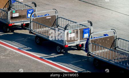 Leeres Gepäck Transport Autos auf Flughafen Start-und Landebahn. Stockfoto