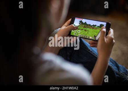 Bukarest, RUMÄNIEN - 10. Mai 2021: Illustrative redaktionelle Konzeptbild eines Kindes, das Minecraft-Spiel auf einem Mobiltelefon spielt. Stockfoto