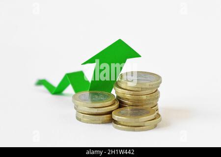 Haufen Euro-Münzen mit grünem Pfeil - Geld Wachstumskonzept Stockfoto
