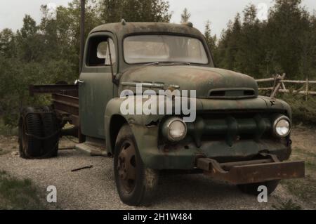 Eine Vintage-Komposition eines alten LKW, der auf einem Feld geparkt ist. Stockfoto