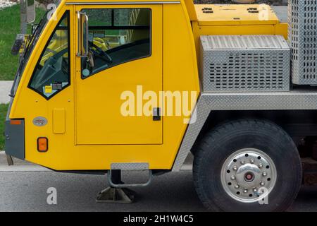 Fragment einer gelben LKW-Krankabine mit einem Vorderrad auf der Fahrerseite Stockfoto