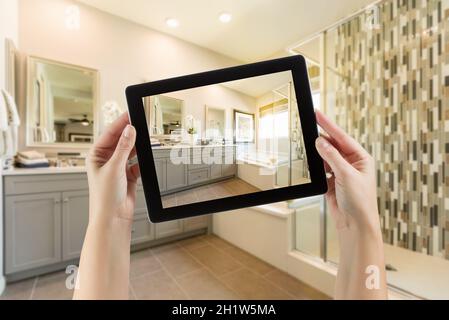 Master Bad Interieur und Hände halten Computer Tablet mit Foto auf dem Bildschirm. Stockfoto