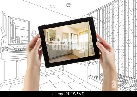 Hände halten Computer Tablet mit Master Badezimmer Foto auf dem Bildschirm und dahinter. Stockfoto