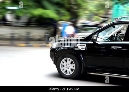 Mumbai, Indien - 13. September 2015: Auf den Straßen Indiens Schwarzer SUV-Wagen, der auf der Straße der Stadt eine scharfe Kurve in voller Geschwindigkeit nimmt, konzentriert sich auf t Stockfoto