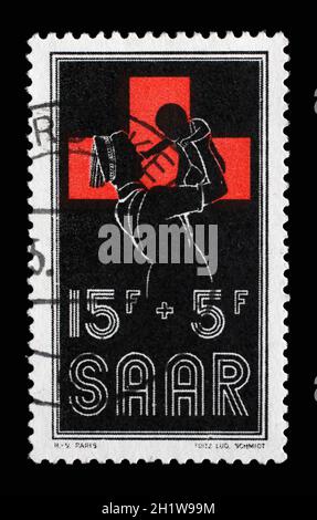 Briefmarke aus Deutschland Saar zeigt Krankenschwester Holding Baby, um 1955 Stockfoto