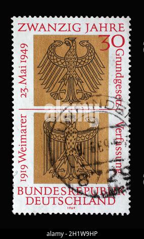 In Deutschland gedruckte Briefmarke zeigt heraldische Adler der Bundes- und Weimarer Republiken, 20 Jahre Deutsches Grundgesetz und 50 Jahre Proclamat Stockfoto