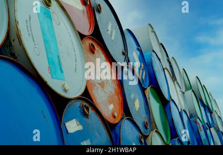 Alte Chemiefässer stapeln sich. Blaue und rote Ölfass. Stahlöltank. Lager für giftige Abfälle. Gefährliche Chemikalienfass. Industrieabfälle im Tank. Gefährlich Stockfoto