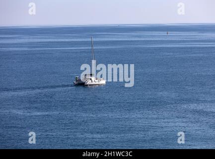 Polignano a Mare, Italien - 17. September 2019: Weißer Katamaran gegen die blaue Adria in Polignano a Mare. Italien Stockfoto