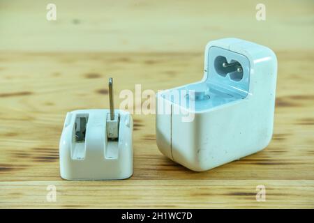 Alte Adapter Ladegerät Schäden, die auf einer hölzernen Hintergrund. Stockfoto