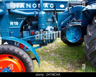 Seitenansicht des Motorblocks eines perfekt restaurierten alten HANOMAG Traktors in blau mit roten Felgen in der Nähe der Kleinstadt Nesselwang in Bayern. Stockfoto