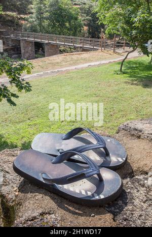 Sandalen über Felsen neben dem Rasen-Erholungsgebiet des Acebo Naturschwimmbads. Im Herzen der Sierra de Gata. Caceres, Extremadura, Spanien Stockfoto