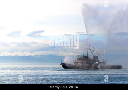 Das schwimmende Schleppboot sprüht Wasserstrahlen Stockfoto