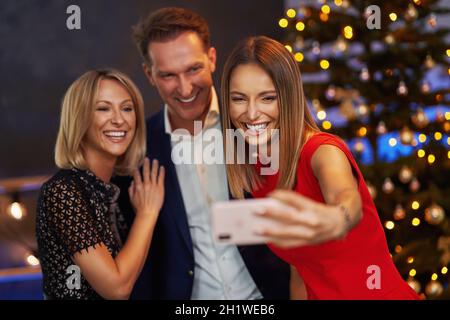 Geschäftsfreunde feiern weihnachtsfeier mit Selfie Stockfoto