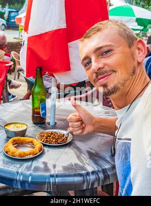 Tourist mit Daumen nach oben für nepalesisches Essen Frühstück mit Sel Roti und Kichererbsen in Kathmandu Nepal. Stockfoto