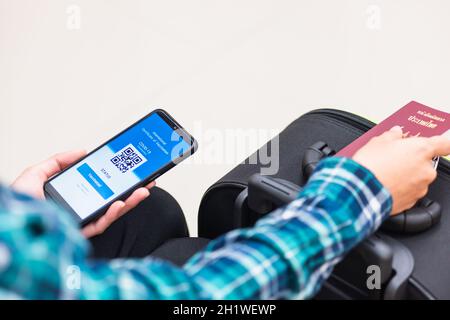 Impfpass, Reisender Mann mit Gesundheitspass der Impfpass-Zertifizierung auf Smartphone-App am Flughafen vor dem Einsteigen in das Flugzeug während der coro Stockfoto