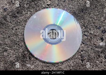 Alte gebrauchte Compact Disc auf einer asphaltierten Straße Stockfoto