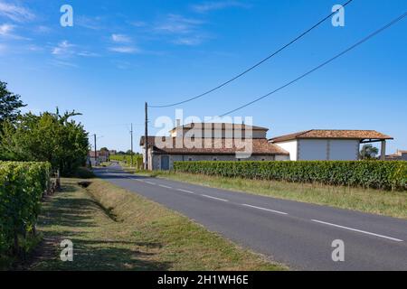 Eine Landstraße nur wenige Kilometer außerhalb von Saint-Émilion im Herzen des Weinbaugebiets AOC Saint-Émilion, Südfrankreich Stockfoto