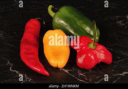 Stillleben von natürlich angebauten grünen Glocken, roten und gelben Paprika. Stockfoto