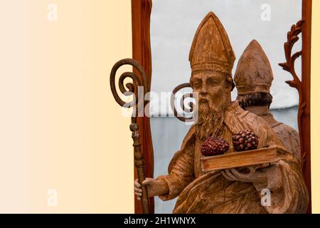 Holzskulptur eines Priesters mit Opfergaben in der Hand und Spiegelung Stockfoto