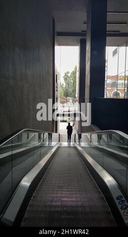 Ukraine, Kiew - 24. September 2019: Rolltreppe in der Mall. Abstrakte silberne Rolltreppe im Inneren des Einkaufszentrums. Betonwand Hintergrund. Stockfoto