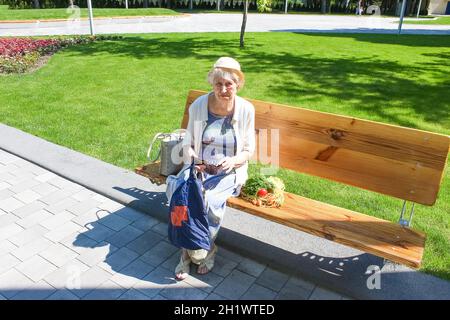 Weibliche Hände halten leere Handtasche nach dem Einkaufen im Park. Ältere Frau zeigt ihre leere Brieftasche. Insolvenz. Das Konzept der Armut. Stockfoto