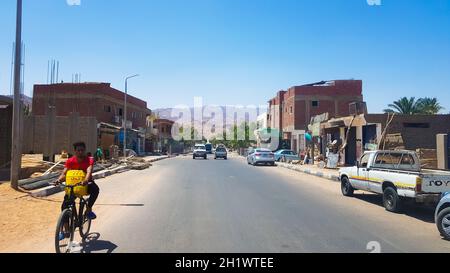 Ägypten, Dahab - 20. Juni 2019: Ein Araber fährt mit dem Fahrrad durch eine der Straßen von Dahab. Desert Street. Ägyptische Wohngebäude. Die Stadt D Stockfoto