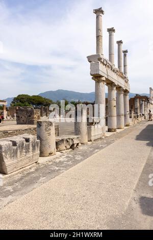 Pompeji, Neapel, Italien - 26. Juni 2021: Das Forum von Pompeji mit dem Eingang zur Basilika. Ruinen einer alten Stadt, die durch den Ausbruch von zerstört wurde Stockfoto