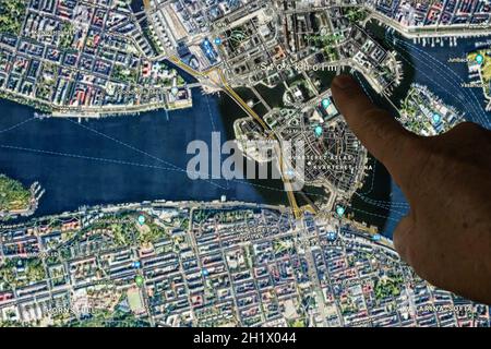 Udine, Italien. 21. August 2021. Die Google Maps-Satellitenansicht von Stockholm, der Hauptstadt Schwedens, wird mit einem Finger angezeigt Stockfoto