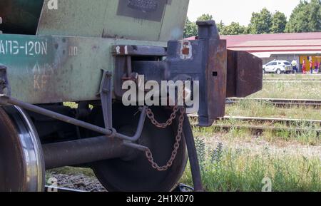 Wagen auf Schienen trainieren. Veraltete Technologie zum Verbinden von Güterzugwagen. Ölfracht-Anhängergehäuse zum Andocken. Eine Zugwagenkupplung, die sie verbindet Stockfoto