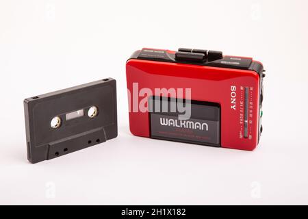 HUETTENBERG, DEUTSCHLAND - 2021-04-07: Schöner, alter Sony WALKMAN ® WM-24 in Rot mit schwarzer Audiokassette vor hellem Hintergrund. Stockfoto