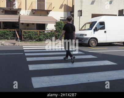 TURIN, ITALIEN - CA. JULI 2021: Frau auf Zebraüberquerung Stockfoto