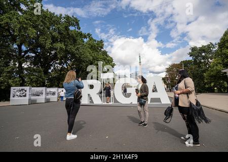 Riga, Lettland. 22. August 2021. Touristen werden vor dem Symbol der Stadt fotografiert Stockfoto