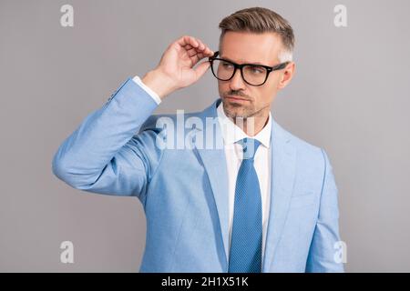 Erfolgreicher Mann in Geschäftsanzug und Brille auf grauem Hintergrund, Erfolg Stockfoto