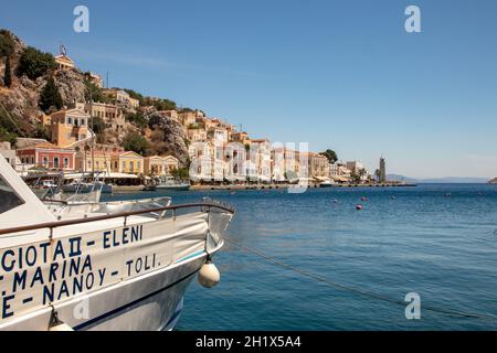 SYMI, Griechenland - 03. JUNI 2021. Der Hafen von Symi Stadt mit den Bezirken Chorio und Gialos ist einer der schönsten und romantischsten in der ganzen A Stockfoto